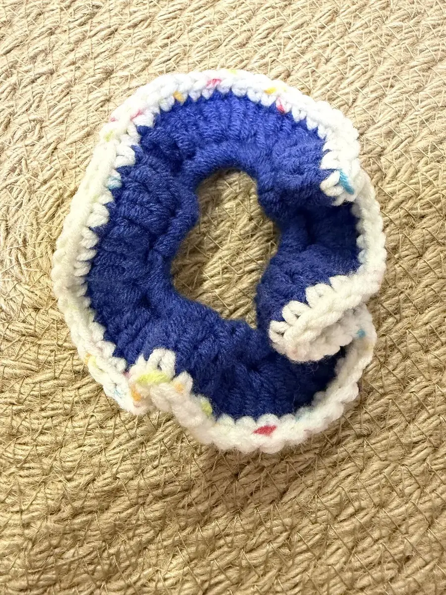 A handmade ruffle scrunchie in navy with a cream confetti edge.