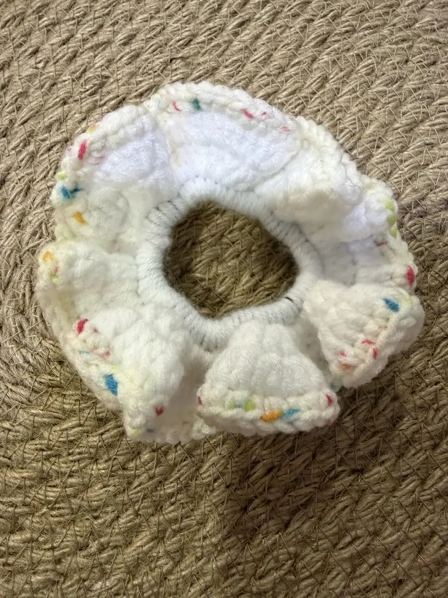 A handmade ruffle scrunchie in white with rainbow confetti flecks.