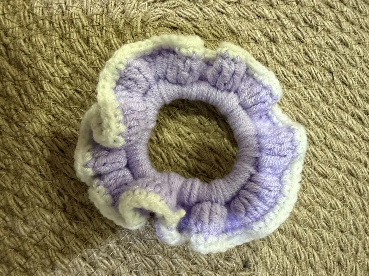 A handmade ruffle scrunchie in lilac with a cream edge.