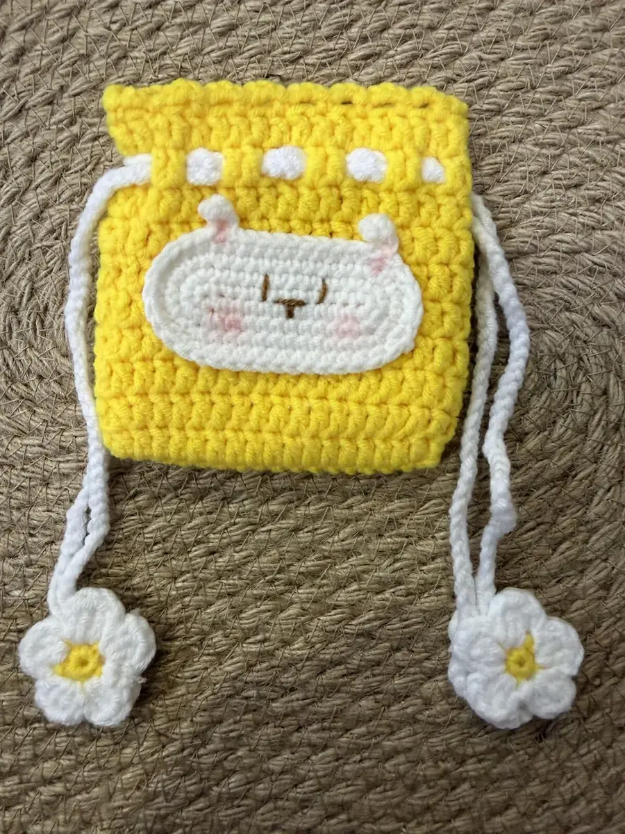 A yellow bunny drawstring pouch with flower tassels.
