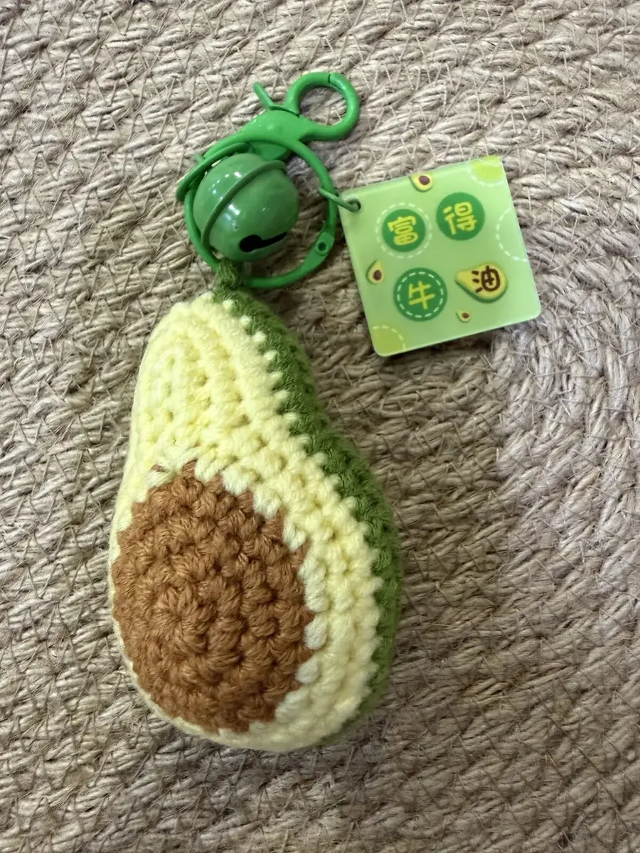 An avocado keychain with a small bell.